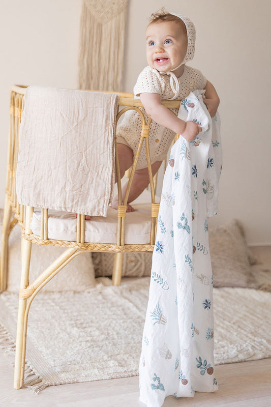 baby with soft bamboo and cotton blanket in play pen
