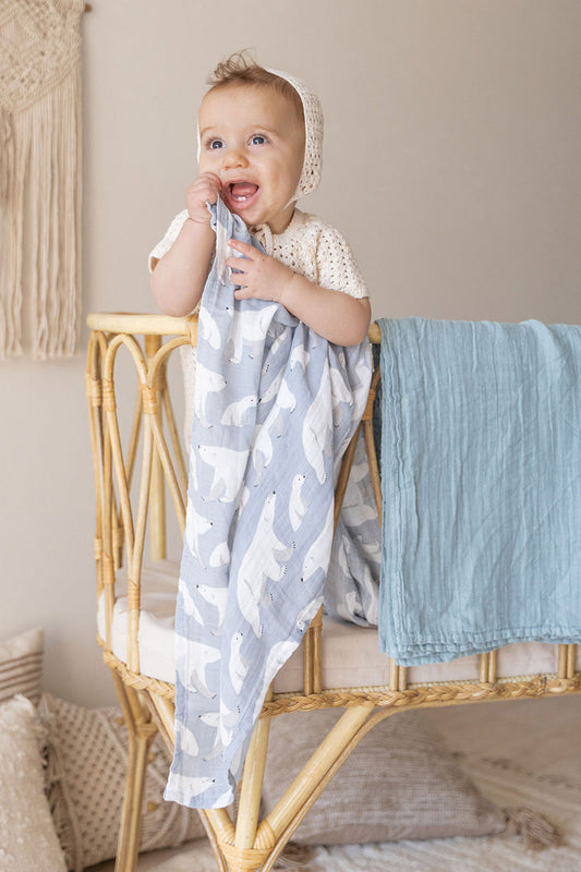 baby in a cradle with bamboo and cotton blanket