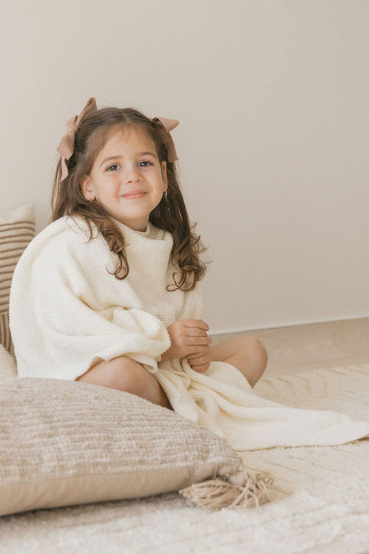 cuddly girl with a white blanket on floor with pillow