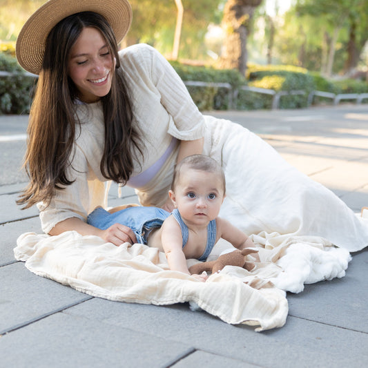mom and baby on soft blanket outdoors